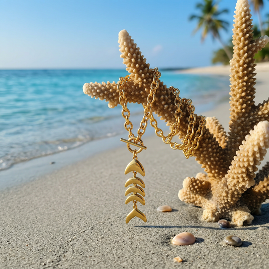 Fish Bold Necklaces with a fish pendant on a piece of coral on a beach.