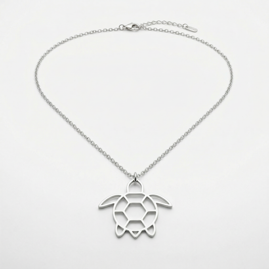 Silver turtle pendant necklace on a light gray background